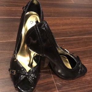 Black patent peep toe pump with gold tone buckle